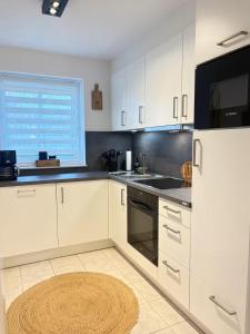 a kitchen with white cabinets and a large window at Sielkate in Dornum