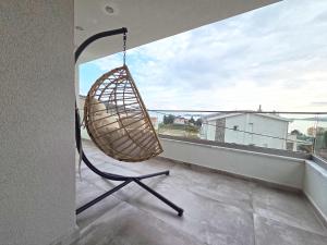 a swinging chair on a balcony with a view at Ocaso Luxury Apartment in Nea Peramos