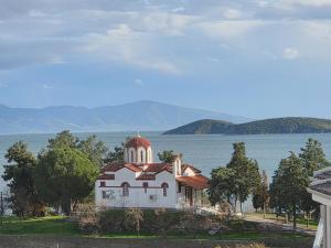 a large white building on the shore of a body of water at Ocaso Luxury Apartment in Nea Peramos