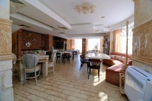 a living room with a couch and tables and chairs at Бутиков хотел History in Haskovo