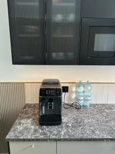 a toaster on a kitchen counter with two bottles of water at Brzostek Apartamenty in Marki +2 photos