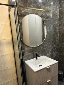 a bathroom with a sink and a mirror at Brzostek Apartamenty in Marki