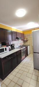 a kitchen with brown cabinets and a white refrigerator at Azalea in Canazei