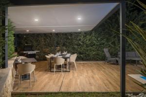 a patio with tables and chairs and a wall of plants at Villa Golden Shine in Funtana