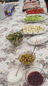 a table with plates of food and bowls of fruit at Leśny Dwór - śniadanie i parking w cenie in Szczecinek