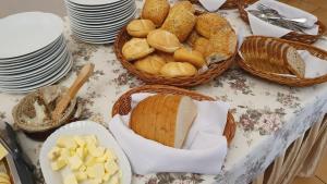 a table with baskets of bread and baskets of cheese at Leśny Dwór - śniadanie i parking w cenie in Szczecinek +38 photos