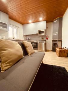 a living room with a couch and a kitchen at Casinha da Ti'Augusta in Lamego