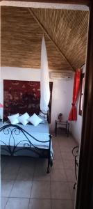 a bedroom with a bed with a wooden ceiling at Villa Nianing in Nianing