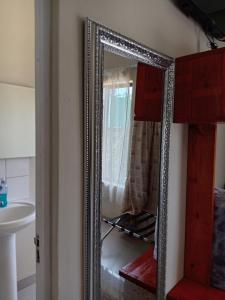 a mirror in a bathroom with a sink at Hlalanathi Lodge - 9 Shepstone Road, Harding in Harding