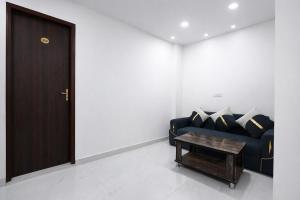 a living room with a blue couch and a table at FabHotel Resto Relax in New Delhi