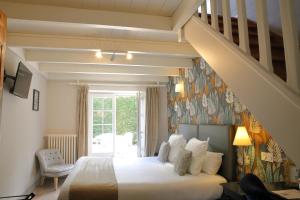 a bedroom with a bed and a staircase at Le Relais Des Landes - Demeures et Chateaux in Ouchamps +89 photos