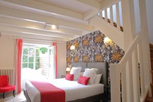 a bedroom with a bed with red and white pillows at Le Relais Des Landes - Demeures et Chateaux in Ouchamps