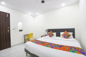 a bedroom with a large white bed with colorful pillows at FabHotel Resto Relax in New Delhi