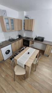 a kitchen with a wooden table and chairs in it at Sun Stream Apartment in Pamporovo