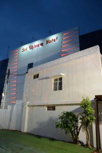 a white building with a sign on the side of it at Sri Shivam Hotel in Gondia +10 photos