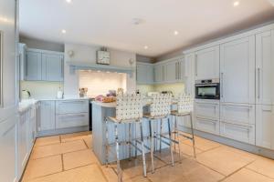 a kitchen with blue cabinets and bar stools at 4 Bed in Catterick oc-y33625 in Catterick Bridge