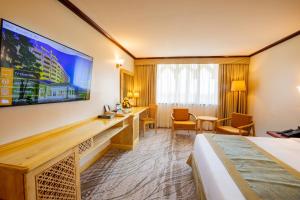 a hotel room with a bed and a flat screen tv at Dar es Salaam Serena Hotel in Dar es Salaam