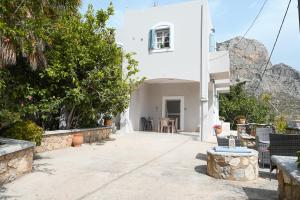 a white house with a table and chairs at Skalia Mountain Sea Serenity in Kalymnos