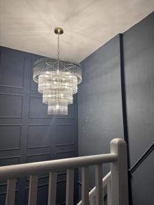 a chandelier in a room with a blue wall at The Royal Keep Hotel in Dudley in Dudley