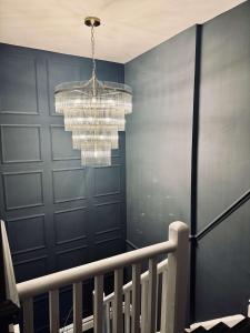 a chandelier in a hallway with a blue wall at The Royal Keep Hotel in Dudley in Dudley