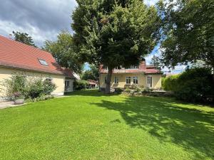 a large yard with a house and a tree at Cottage in Kleinmachnow