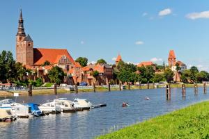 a group of boats in the water near a town at Töpferhäuschen Tangermünde in Tangermünde