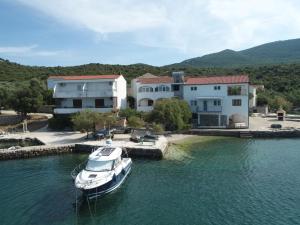 a boat docked in the water in front of a house at Robinson Dora in Putniković