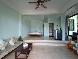 a living room with a couch and a ceiling fan at Marine House Koh Tao in Ko Tao