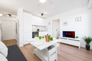 a white living room with a white table and a tv at Haut de Monaco - Vue panoramique mer et ville - FE in Beausoleil