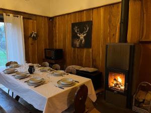 a dining room with a table and a fireplace at Le Saint Michel in Otterswiller