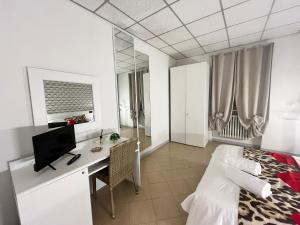 a bedroom with a bed and a desk with a television at Hotel Elite in Turin