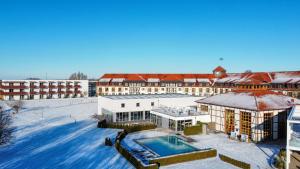 a large building with a swimming pool in the snow at ROBINSON Fleesensee in Göhren-Lebbin