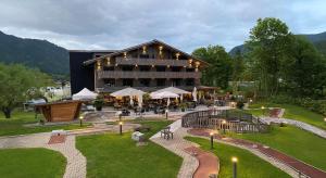 a large building with a restaurant in front of it at Gruppenhaus Frutigresort in Frutigen