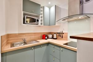 a kitchen with a sink and a microwave at L' échafaud - Apparts de standing - Centre historique in Périgueux +64 photos