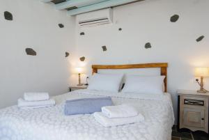 a bedroom with a white bed with towels on it at Efthymia apartments in Faros