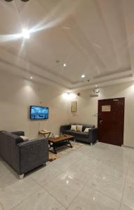 a living room with two couches and a tv at شقق درة المصيف in Taif