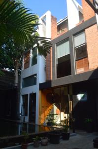 a building with a palm tree in front of it at Ruda Mini Hotel in Phumi Ta Phul