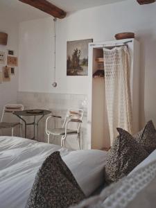 a bedroom with a bed and a table and chairs at La Potentille in Lieuran-Cabrières