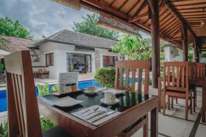 a dining table and chairs on the patio of a villa at Frangipani Beach Hotel in Lovina