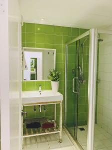a green bathroom with a sink and a shower at Peking Garden Youth Hostel in Beijing +56 photos