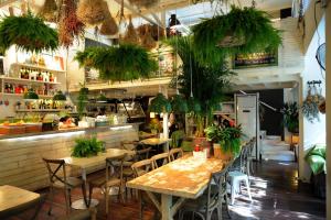 a restaurant with tables and chairs and potted plants at Peking Garden Youth Hostel in Beijing