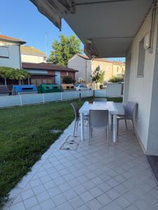 a white table and chairs on a patio at Appartamento Solution Garibaldi in Marina di Ravenna