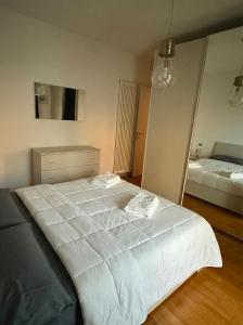 a large white bed in a bedroom with a mirror at Appartamento Solution Garibaldi in Marina di Ravenna