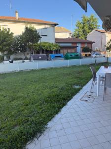 a patio with a table and chairs in a yard at Appartamento Solution Garibaldi in Marina di Ravenna +3 photos