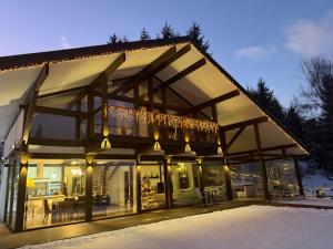 a house with glass doors and lights on it at Alpine Lounge in Vatra Dornei
