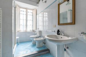 a white bathroom with a sink and a toilet at Lucca Charm in Lucca