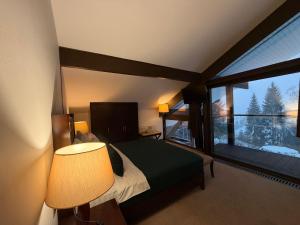 a bedroom with a bed and a large window at Alpine Lounge in Vatra Dornei