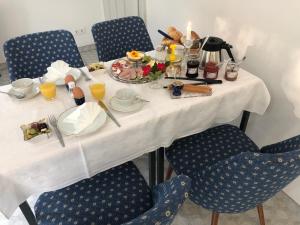 a table with breakfast food on it with blue chairs at Alte Leimsiederei in Herrnhut