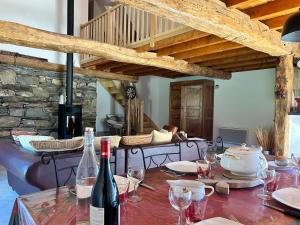 a table with wine bottles and glasses on it at Le Gîte Escalletas in Arrens-Marsous