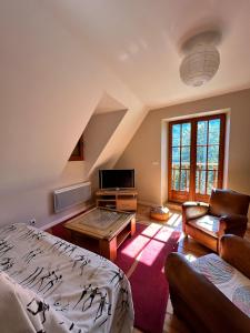a living room with a bed a couch and a tv at Le Gîte Escalletas in Arrens-Marsous